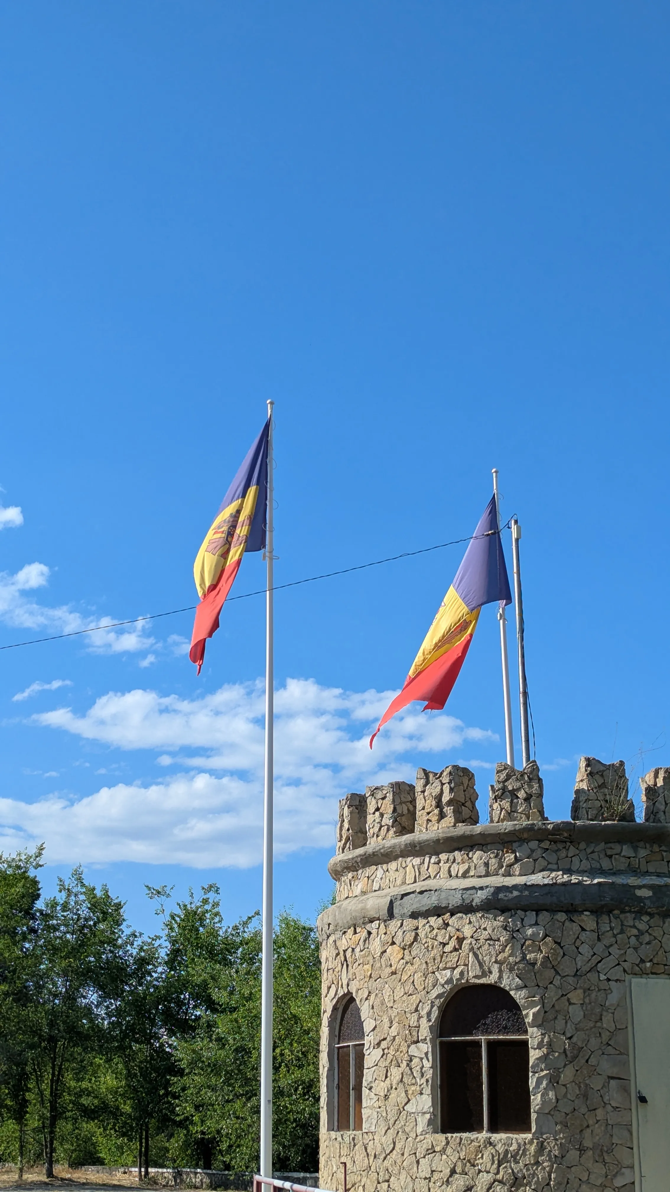 Budka stylizowana na starą kamienną wieżę z blankami, dwie mołdawskie
flagi