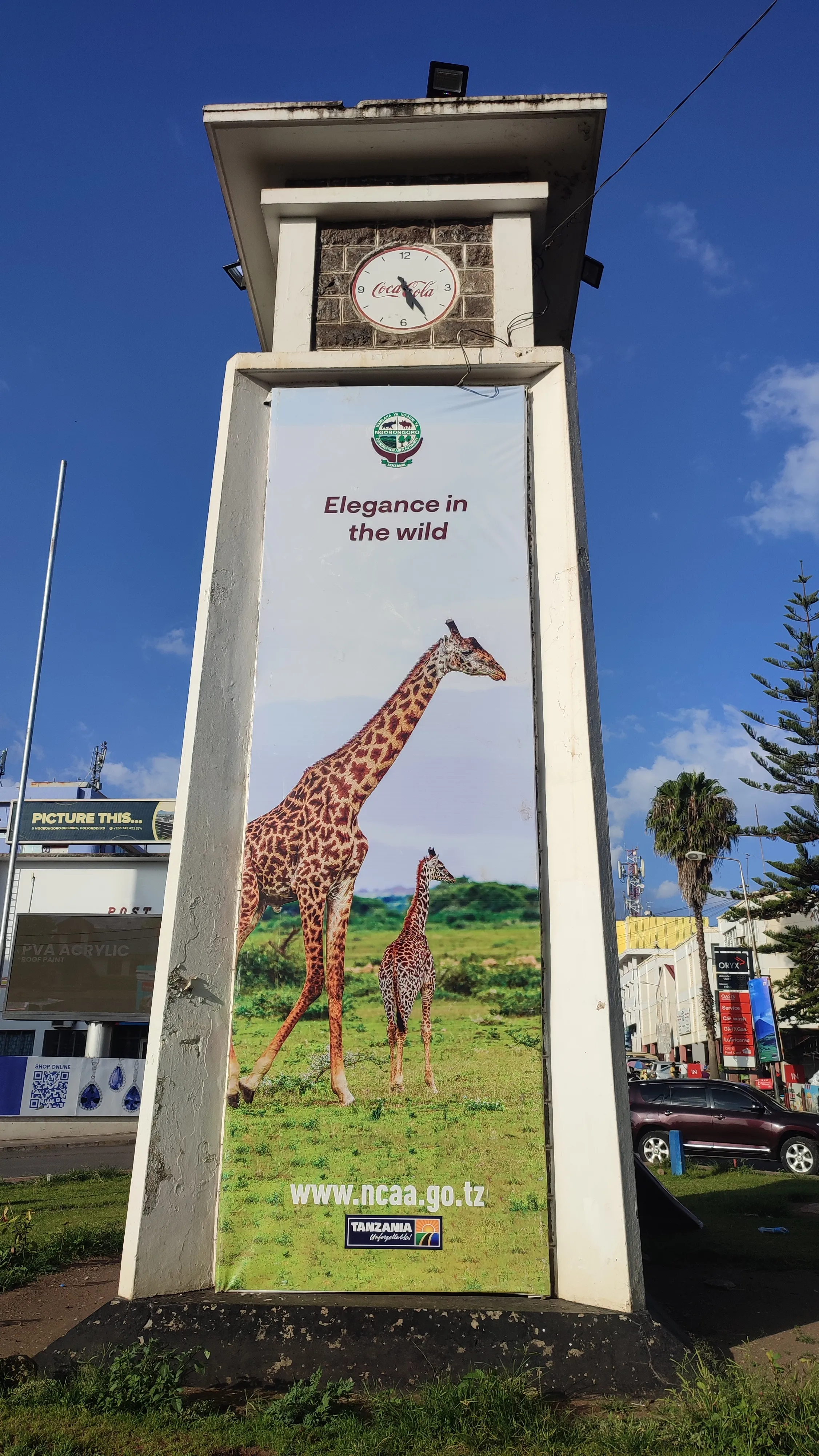 Wieża zegarowa z reklamą z żyrafami