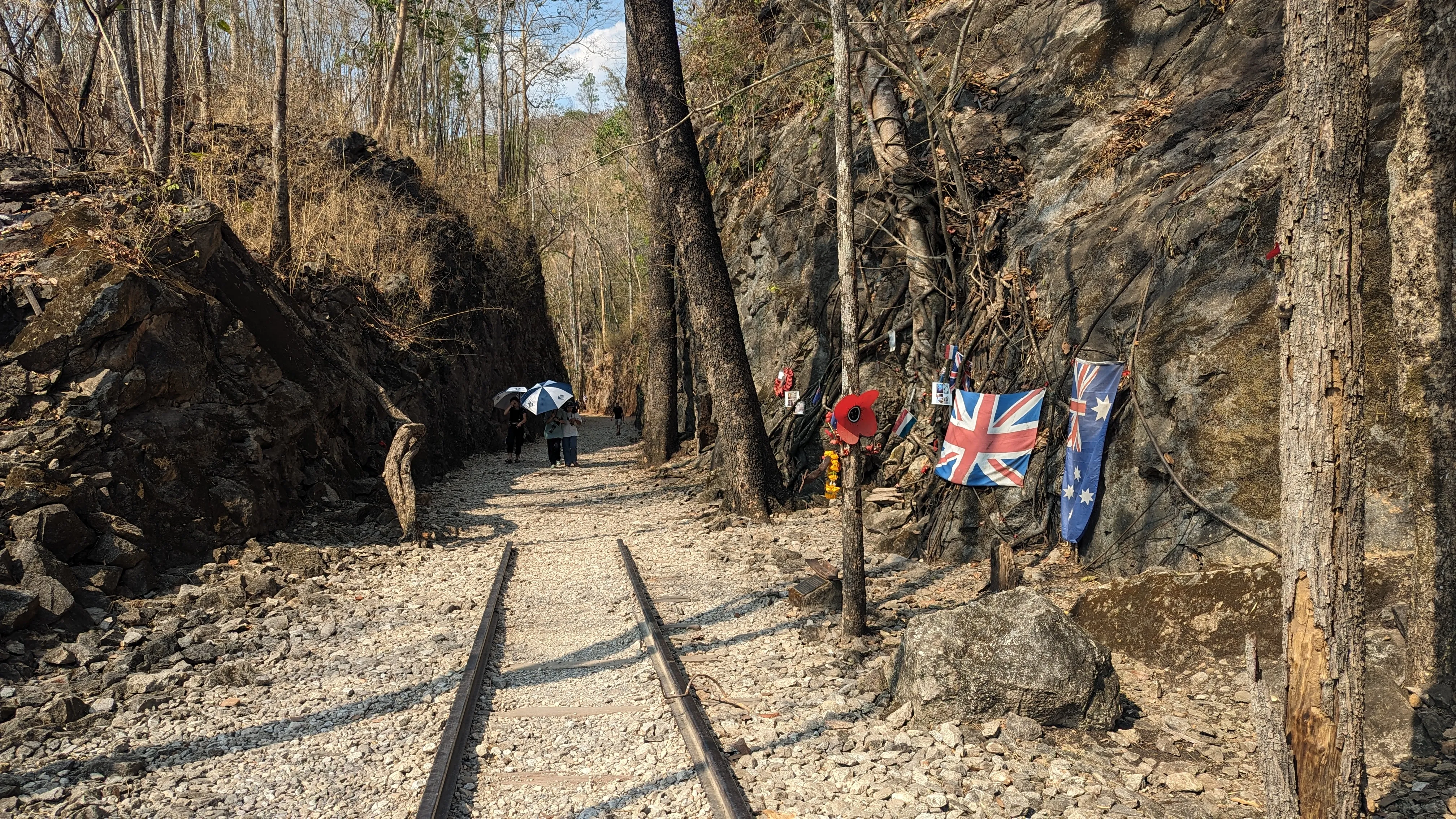 Dwie szyny biegnące w stronę skalnego przesmyku, przechodzące w żwirową ścieżkę. Na skale obok
wiszą flagi Australii i Wielkiej
Brytanii